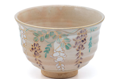 Floral cream chawan, closer front view emphasising the painted flower-and-grass sprays around the body