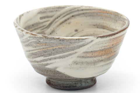 Closeup of one teacup showing the swirled brushwork and glazed interior.