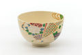 Kyo-yaki matcha bowl (chawan), front view, cream glaze with a colorful geometric floral band.