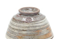 Underside of one teacup showing the foot ring and a small maker's stamp.