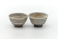 The two teacups side by side, front view, showing the marbled hakeme glaze.