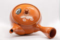 Japanese Kyusu - 帯アミ Floral Red Shudei Tokoname-yaki Obi-ami Teapot - 265ml - top-down view showing the lid knob, handle, and white daisy decoration