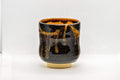 Japanese Teacup - Drip-Glazed Tsutsu-gata Yunomi - 160ml - front view showing the black glaze with orange drip streaks