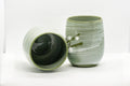 Japanese Teacups - Meoto Pair of Green Floral Yunomi - one teacup resting on its side showing the dark interior beside one upright