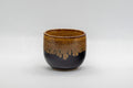 Japanese Teacup - Drip-Glazed Guinomi - 35ml - front view showing the amber glaze dripping over the black exterior