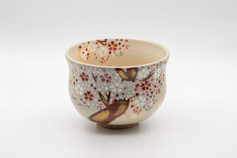 Japanese Matcha Bowl - Torasuke Kyo-yaki Komogai-nari Chawan - angled front view showing the red and white sakura blossom decoration on the cream glaze
