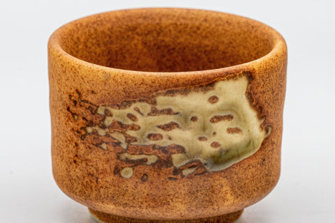 Japanese Teacup - Orange Glazed Hantsutsu-gata Guinomi - 45ml - front closeup showing the burnt-orange glaze with a patch of dark green ash glaze