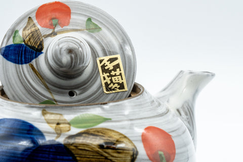 Tezumi — Floral brush-glazed kyusu teapot, angled rear view showing the side handle and fruit painting