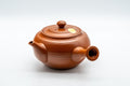 Japanese Kyusu - 有馬 Maru-gata Debeso Tokoname-yaki Teapot - 350ml - three-quarter front view of the red Tokoname-yaki clay teapot with side handle and spout