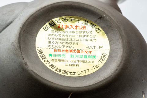 Tezumi — Orchid-decorated kyusu teapot inverted to show the base with the maker's label
