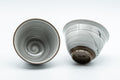 Japanese Teacups - Pair of White Glazed Yunomi with Long Grass Motifs - 100ml - one cup upright and one tipped to show the base