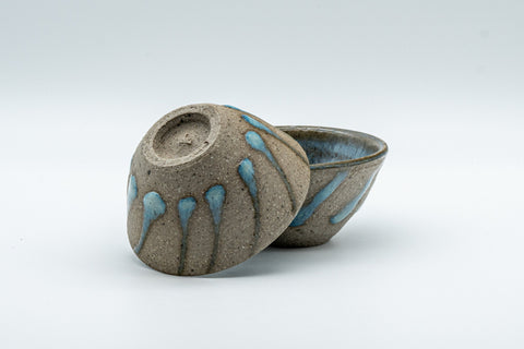 Japanese Teacups - Pair of Stoneware Asagao-gata Guinomi with Cyan Glazed Interior - 50ml - angled view with one cup tipped to show its base
