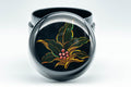 Japanese Natsume - Jeweled Lacquer Matcha Tea Caddy - 100ml - top-down closeup of the lid showing the green and gold leaf design accented with red jewels