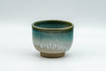 Japanese Teacup - Vibrant Agano-yaki Yunomi - 100ml - front view of the beige teacup with a vibrant turquoise enamel drip