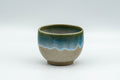 Japanese Teacup - Turquoise Glazed Agano-yaki Yunomi - 90ml - front view of the beige teacup with a turquoise enamel drip near the base