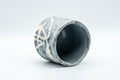 Japanese Teacup - Bamboo Suana Shino Glazed Tsutsu-gata Yunomi with Coaster - tilted view showing the pinhole-textured shino glaze