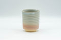 Japanese Teacup - Spiral Tsutsu-gata Hagi-yaki Yunomi - 150ml - front view showing the cream and peach crazed glaze with a white-glazed lip