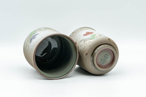 Japanese Teacups - Pair of Floral Green Meoto Yunomi - Arita-yaki - the cups tilted to show the dark glazed interiors