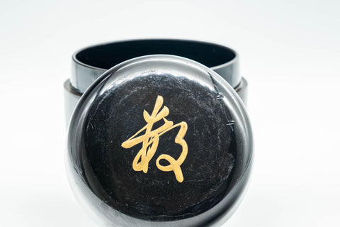 Japanese Natsume - ね Hentaigana Black Lacquer Matcha Tea Caddy - 100ml - angled view showing the gold hentaigana ね character on the lid