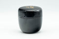 Japanese Natsume - ね Hentaigana Black Lacquer Matcha Tea Caddy - 100ml - closed natsume showing the wood-grain lacquer finish