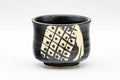Tezumi — Japanese Teacup - Matte Black Glazed Geometric Motif Yunomi - 70ml — tipped to show the interior